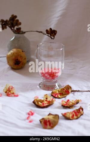 Vertical shot of pomegranate fruit and seeds ready to be made into fresh juice, showing a delicate summer aesthetics Stock Photo
