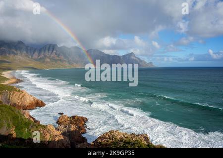 View with rainbow towards Rooi Els and Hanklip from Clarence Drive on the eastern side of False Bay. Cape Town, Western Cape, South Africa. Stock Photo