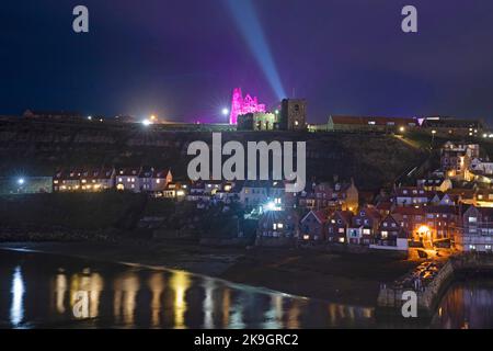 The ruins of Whitby Abbey and harbour at nighttime during its Dracula celebrations in October 2022 Stock Photo