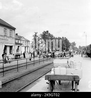 Emmaboda Railway Station. The passenger train consists of older passenger cars made before 1930. The telephone booth in the picture is of the 1930s model, and the presence of military among the travelers makes it likely that the picture was taken sometime during the war years. Stock Photo