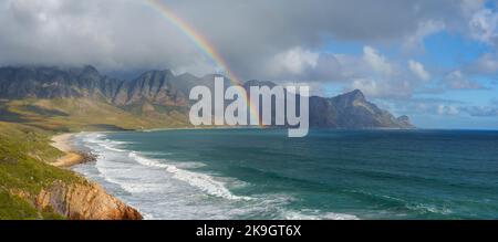 View with rainbow towards Rooi Els and Hanklip from Clarence Drive on the eastern side of False Bay. Cape Town, Western Cape, South Africa. Stock Photo