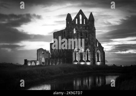 The ruins of Whitby Abbey illuminated in pink as part of the 125 years celebration of Dracula, Whitby, North Yorkshire 24th October 2022 Stock Photo