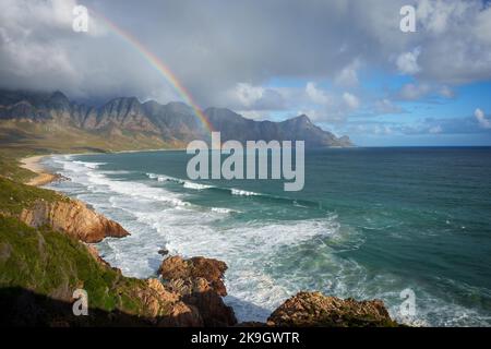 View with rainbow towards Rooi Els and Hanklip from Clarence Drive on the eastern side of False Bay. Cape Town, Western Cape, South Africa. Stock Photo