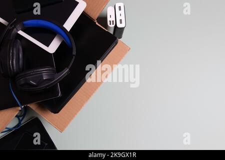 Cardboard box full of old used laptop computers, digital tablets, smartphones, power bank for recycling. Top view. Donation, charity, e-waste Stock Photo