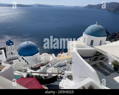 Oia, Santorini, Greece. 2022. Overview of famous blue domed buildings at Oia on the clifftops overlooking the Aegean Sea in Santorini Stock Photo