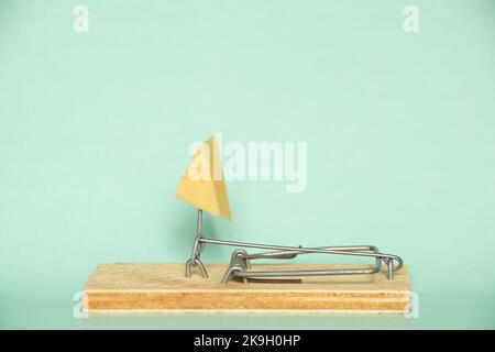 Cheese in a mousetrap on a blue background, free cheese, danger Stock Photo