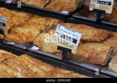 Chisinau, Moldova - October 15, 2022: Refrigerated display case with pastries, price tag for Placinda stretch dough with cabbage, selective focus Stock Photo