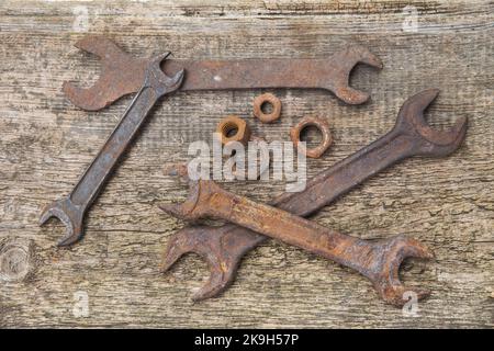 rusty wrenches and nuts on old unpainted boards Stock Photo