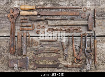 rusty tools lie on old wooden table Stock Photo