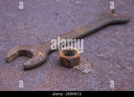 Old wrench and nut on a rusty countertop Stock Photo