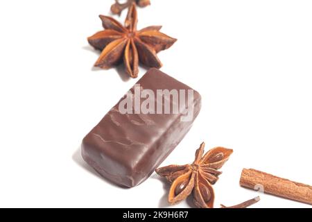 gourmet chocolate bonbons with anise and cinnamon sticks isolated on white background. Stock Photo