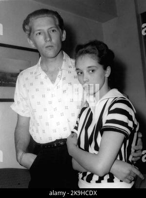 May 23, 1958 - 22 - year - old American rock n' roll singer arrives here with his 15 - year old wife: Jerry Lee Lewis, the American rock n' roll singer, flew into London yesterday with a shock for his fans. For the girl who arrived with him turned out to be his 15 - year - old wife of two months. Her name was Myra, and she is his third wife. Jerry was first married at 15 and again at 17, but this time he says he has found the right girl.When asked if she thought that fifteen was too young to be a wife, Myra explained that back at her home town Memphis, Tennessee, you can marry at the age of te Stock Photo