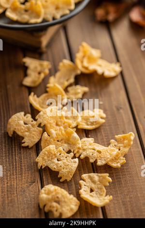 Halloween crispy bat shaped chips on the wooden table. Stock Photo