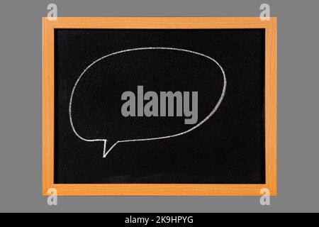 Blank comic speech bubble drawing on chalk blackboard, isolated on middle gray background Stock Photo