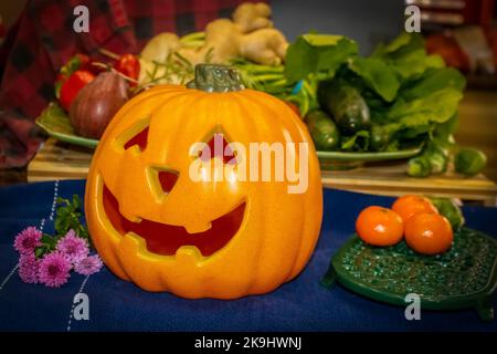 Happy Jackolatern sitting in front of a pile of beggies with flowers - bokeh background Stock Photo