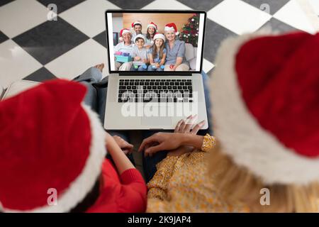 Diverse couple having christmas video call with diverse family Stock Photo