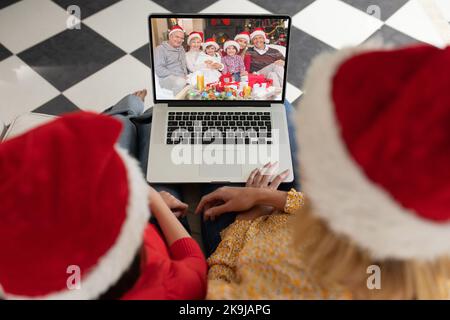 Diverse couple having christmas video call with caucasian family Stock Photo