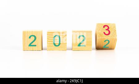 2023 new year concept with wooden cubes on white background. Entering to 2023 new year concept idea. Changing year from 2022 to 2023 with wooden cubes Stock Photo