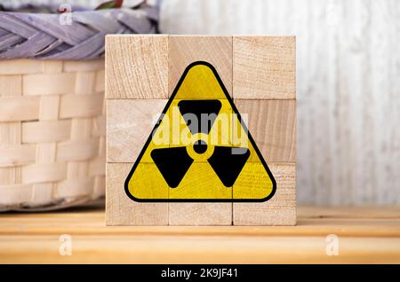 Radioactive ionizing radiation round yellow and black danger symbol painted on a massive rusty metal wall with dark rustic grunge texture background. Stock Photo