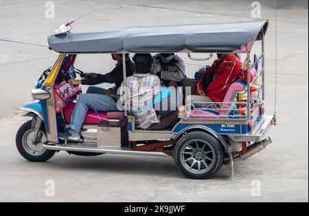 SAMUT PRAKAN, THAILAND, OCT 03 2022, A full taxi tricycle - tuk tuk rides with passenger Stock Photo