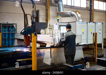 Engineer controls operation of portal plasma cutting machine Stock Photo