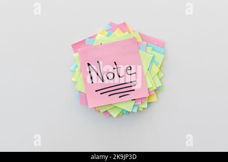 Handwritten word Note on a sticky note with a white isolated background Stock Photo