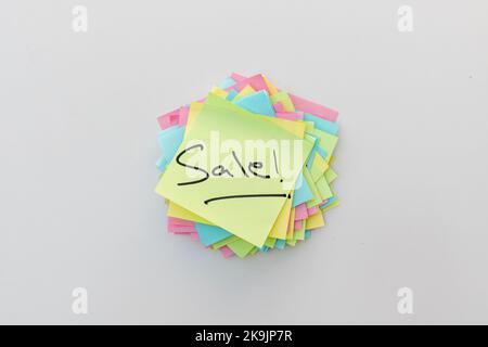 Hand written memo or reminder of a word SALE on a sticky note Stock Photo