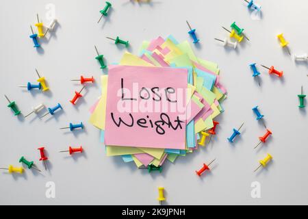 Lose weight hand written text . Motivational reminder on sticky note Stock Photo