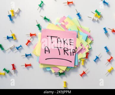 Take a trip handwritten word on a sticky note Stock Photo