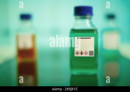 chemical solution glass bottles warning with hazard signs Stock Photo