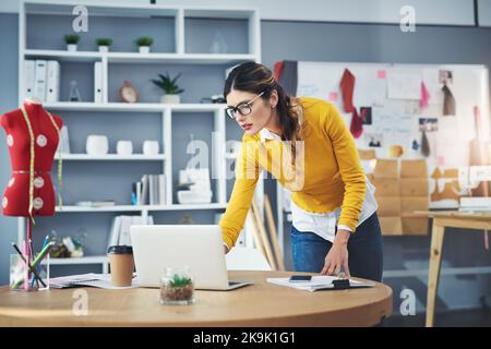 Shes using technology to improve her designs. an attractive young fashion designer in her workshop. Stock Photo