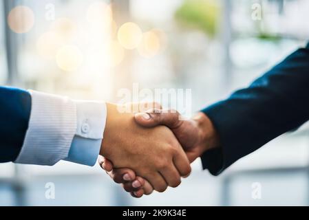 Its a done deal. two unrecognizable businesspeople shaking hands while standing in their office. Stock Photo