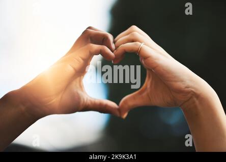 My heart loves your heart. a couple making a heart gesture with their hands outdoors. Stock Photo