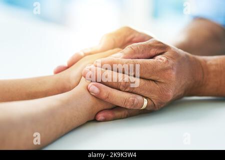 You dont have to look far for help. Closeup of a doctor holding a patients hands in comfort inside of a hospital during the day. Stock Photo