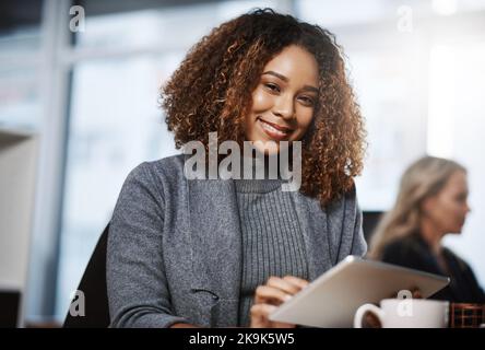 Modern technology helps me become a better expert. Portrait of a young businesswoman using a digital tablet in an office. Stock Photo