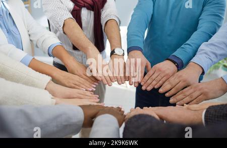 Diverse team of business people join their hands to show concept of teamwork, union, and support Stock Photo