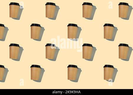 Pattern of cardboard coffee cups with a plastic lid with a hard shadow on a beige background. The concept of ecology, recycling, environmental protection. Stock Photo