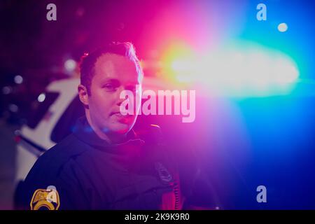 The good ol red and blue. Cropped portrait of a handsome young policeman out on patrol. Stock Photo