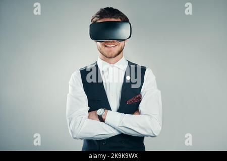 This is the future of business. Studio shot of a handsome young businessman using a vr headset against a grey background. Stock Photo