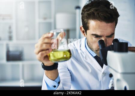 He lets no detail escape the eye. a scientist conducting an experiment in a lab. Stock Photo