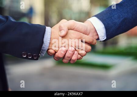 Creating new business partners wherever we go. unrecongizable businessmen shaking hands outside. Stock Photo