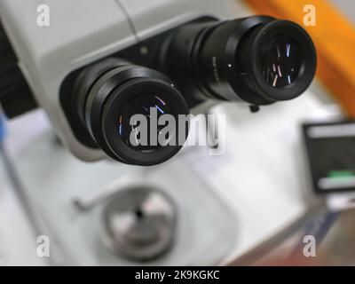 Close-up on optics of a binocular microscope, its base  is in blurred background. Stock Photo