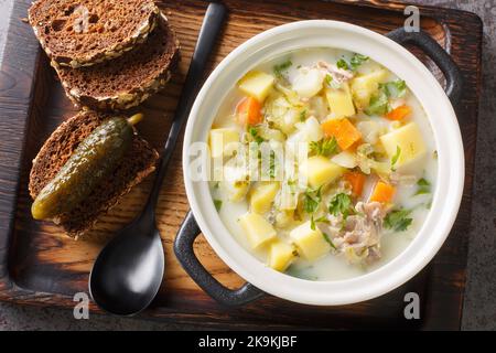 Zupa Ogorkowa Cucumber soup is a traditional Polish and Lithuanian soup made from sour, salted cucumbers and root vegetables closeup on the pot on the Stock Photo