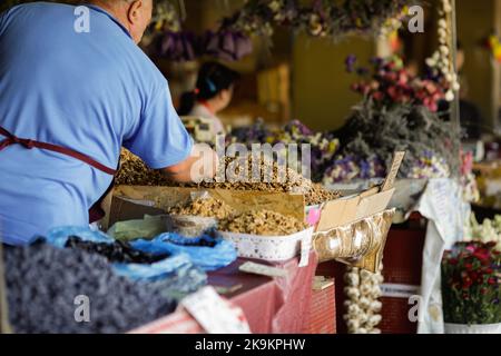 Shallow depth of field (selective focus) details with a farmer selling walnut kernels on a stand in Obor market in Bucharest, Romania. Stock Photo