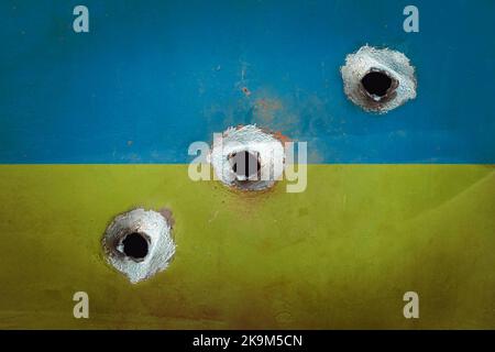 Military conflict in Ukraine background. Flag with bullet holes and crack on concrete wall. concept destruction of the state. bullet holes in the wall Stock Photo