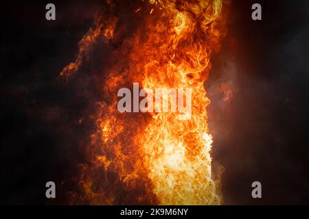 a strong bright flame of fire on a dark background. Stock Photo
