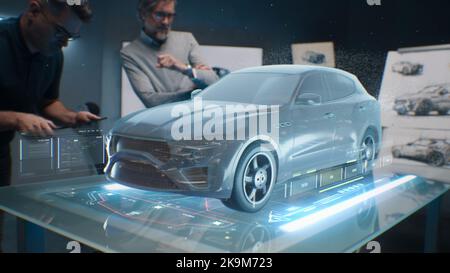 Two male engineers using digital tablet App, developing 3D model of a sustainable eco friendly electric vehicle. Designers testing car bodys air streamline properties testing aerodynamic parameters Stock Photo