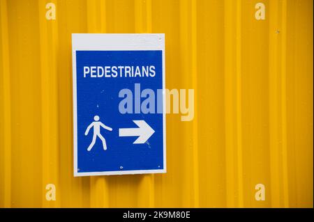 Pedestrian walkway sign at construction building site fence Stock Photo