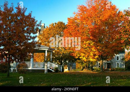 Sunrise in Danville, Vermont during fall foliage season, with a church and gazebo on the Green Stock Photo