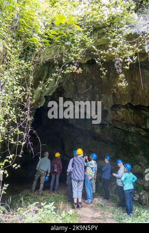 UK, England, Devonshire. The William Pengelly Cave Studies Centre in Buckfastleigh. A Geologist guide showing visitors into Reeds Cave entrance. Stock Photo